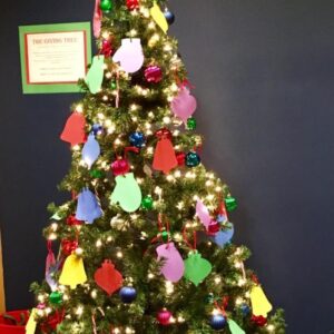 Christmas Tree with white lights, real ornaments, and paper mittens and paper bell ornaments on it