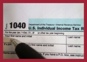 1040 Tax Form with a pen about to write on it